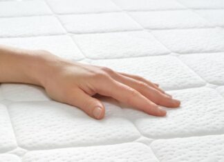 Comment nettoyer un matelas ? Main de femme sur un matelas