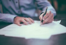 Comment faire un CV efficace ? Personne écrivant sur une feuille