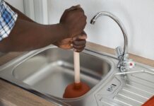 Comment déboucher un évier ? Homme qui débouche un évier