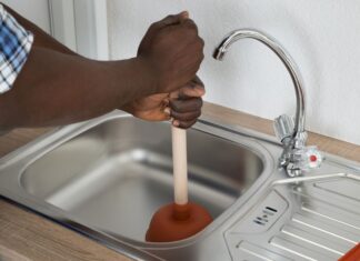 Comment déboucher un évier ? Homme qui débouche un évier