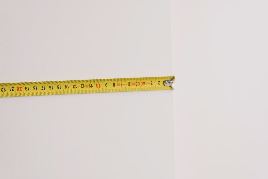 mètre jaune sur mur blanc calculer volume ou superficie