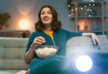 Guide pour choisir un vidéoprojecteur adapté à vos besoins femme regardant un videoprojecteur